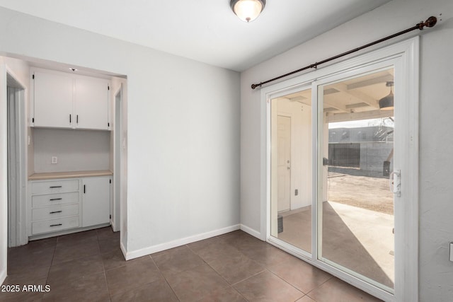 doorway with dark tile patterned flooring