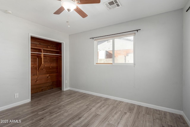 unfurnished bedroom featuring light hardwood / wood-style floors, a closet, and ceiling fan