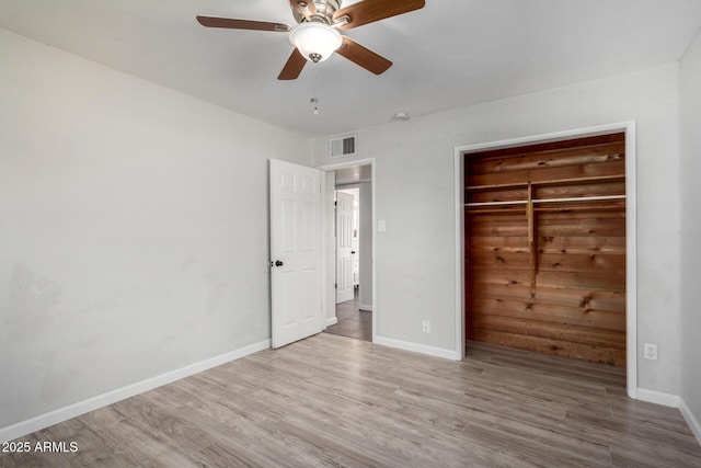 unfurnished bedroom with ceiling fan, a closet, and light hardwood / wood-style flooring