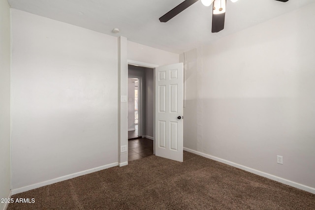 unfurnished room featuring dark colored carpet and ceiling fan