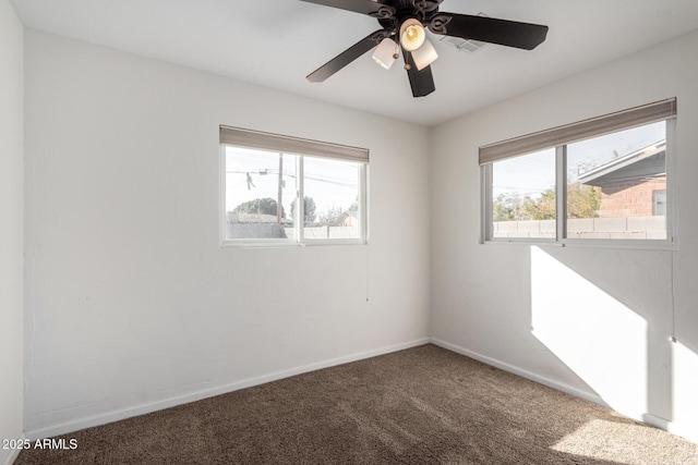 carpeted spare room with a wealth of natural light and ceiling fan