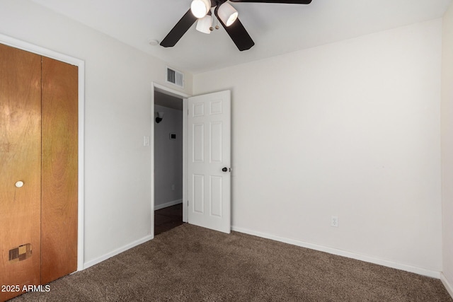 unfurnished bedroom featuring dark colored carpet, ceiling fan, and a closet