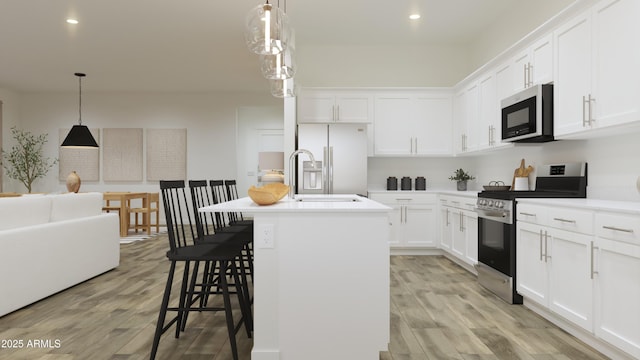 kitchen with white cabinetry, appliances with stainless steel finishes, a kitchen breakfast bar, an island with sink, and pendant lighting