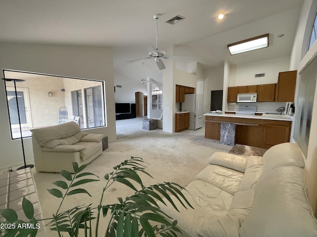 living room featuring light carpet, ceiling fan, sink, and high vaulted ceiling