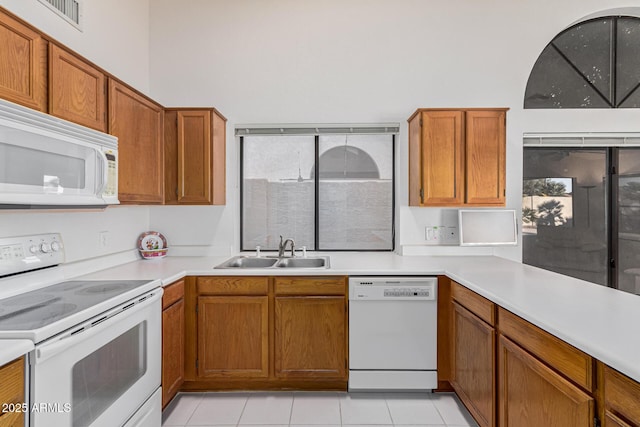 kitchen featuring light tile patterned floors, sink, and white appliances