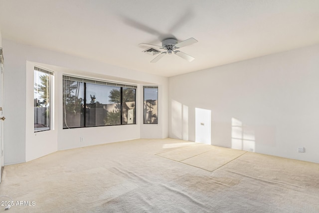 spare room featuring ceiling fan and light carpet