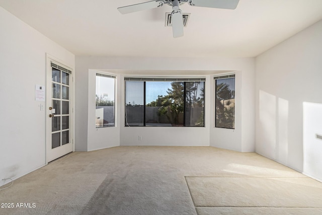 unfurnished room featuring ceiling fan and light carpet