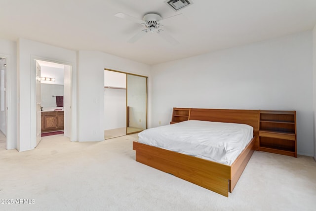 bedroom featuring ceiling fan, light colored carpet, connected bathroom, a closet, and pool table