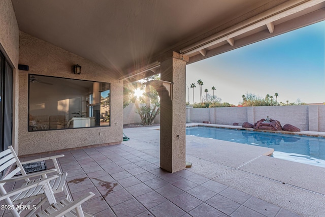 pool at dusk with a patio area