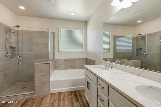 full bath with a sink, visible vents, wood finished floors, and a shower stall