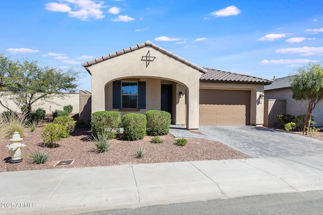 mediterranean / spanish home with fence, driveway, stucco siding, a garage, and a tiled roof