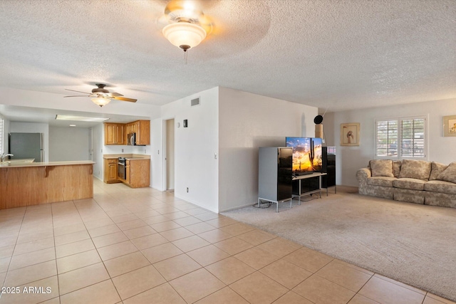4333 E Desert Cactus St, Phoenix, AZ 85032 - living room featuring a textured ceiling, light tile patterned floors, light colored carpet, and ceiling fan