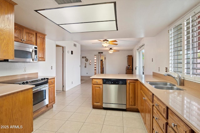 4333 E Desert Cactus St, Phoenix, AZ 85032 - kitchen with stainless steel appliances, a sink, light countertops, and brown cabinets