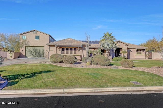 view of front of home with a garage, a front yard, and solar panels