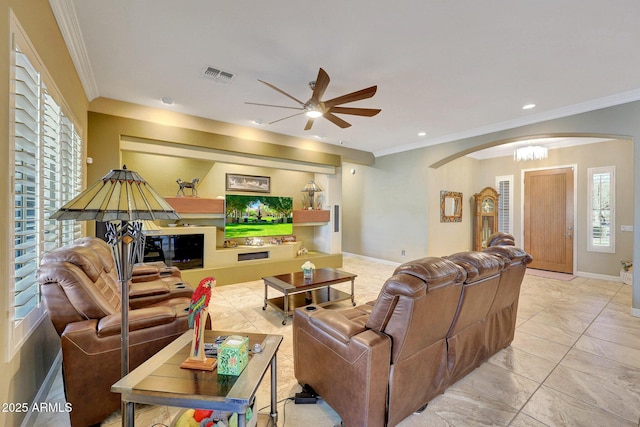 living room featuring ceiling fan with notable chandelier and ornamental molding