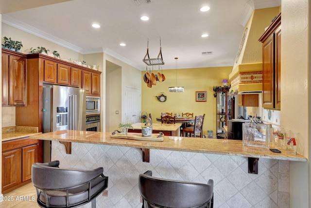 kitchen featuring a kitchen breakfast bar, crown molding, kitchen peninsula, and stainless steel appliances