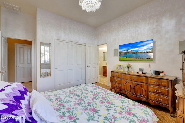 bedroom featuring light wood-type flooring and a chandelier