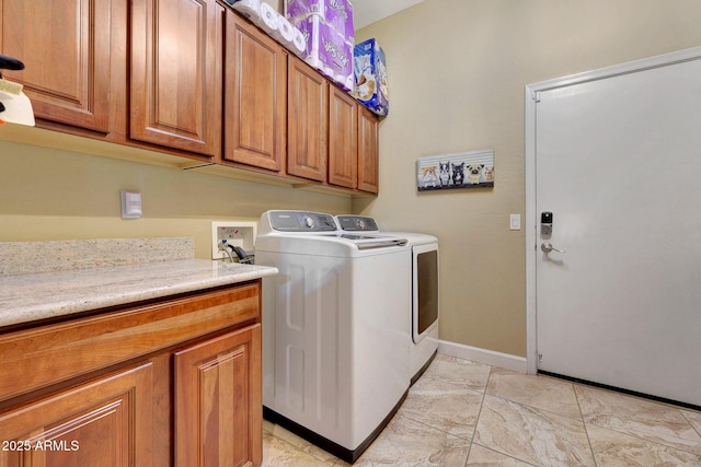 clothes washing area featuring cabinets and washing machine and clothes dryer