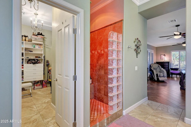 bathroom with ceiling fan with notable chandelier, walk in shower, and crown molding