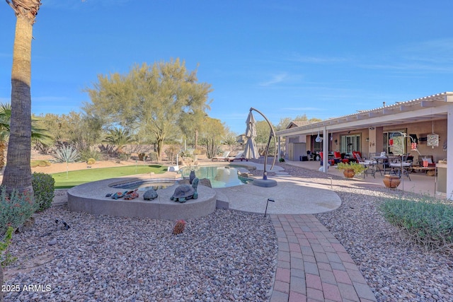 view of yard featuring a patio area and a swimming pool with hot tub