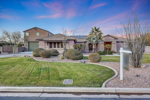 view of front of property with a yard and solar panels