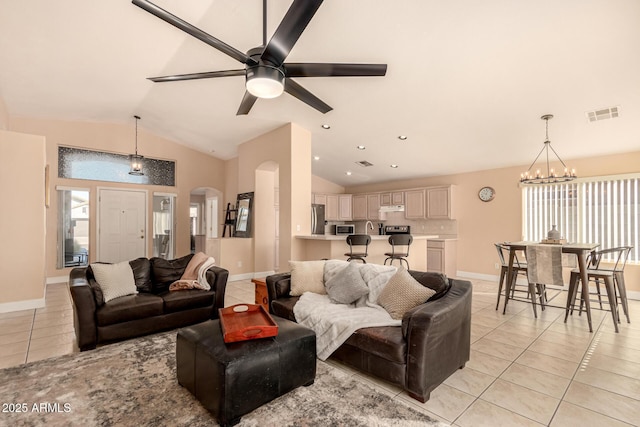 living room featuring vaulted ceiling, ceiling fan with notable chandelier, and light tile patterned floors