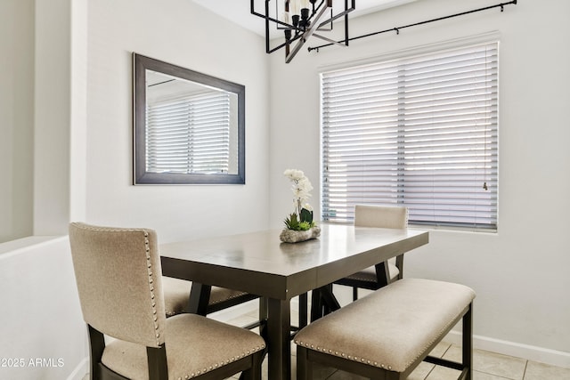 dining space featuring light tile patterned flooring, baseboards, and a chandelier