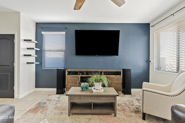 tiled living area with a fireplace, baseboards, and ceiling fan