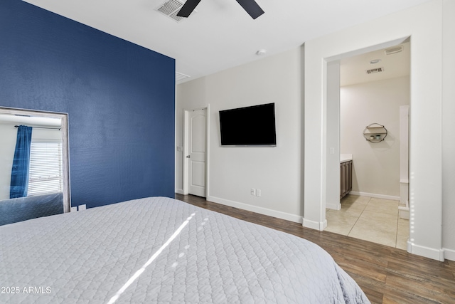 bedroom featuring visible vents, baseboards, wood finished floors, and a ceiling fan