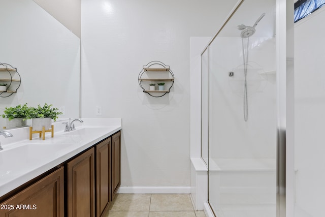 bathroom featuring a walk in shower, a sink, tile patterned flooring, double vanity, and baseboards