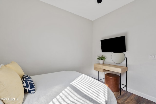 bedroom with ceiling fan, dark wood-type flooring, and baseboards