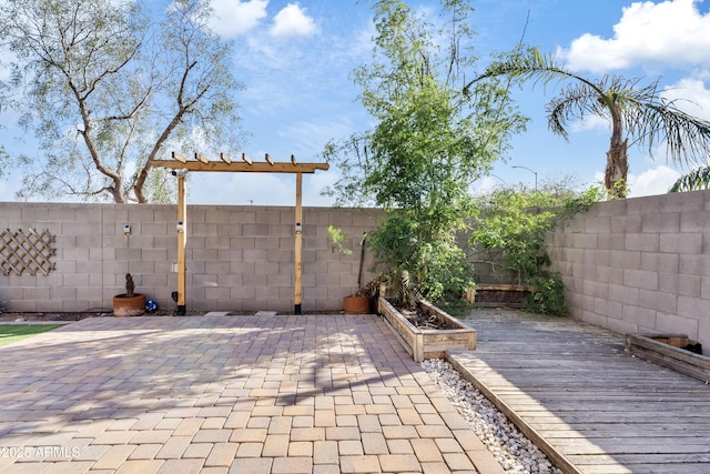 view of patio / terrace with a deck, a vegetable garden, and a fenced backyard