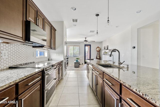 kitchen with visible vents, decorative backsplash, light tile patterned flooring, stainless steel appliances, and a sink