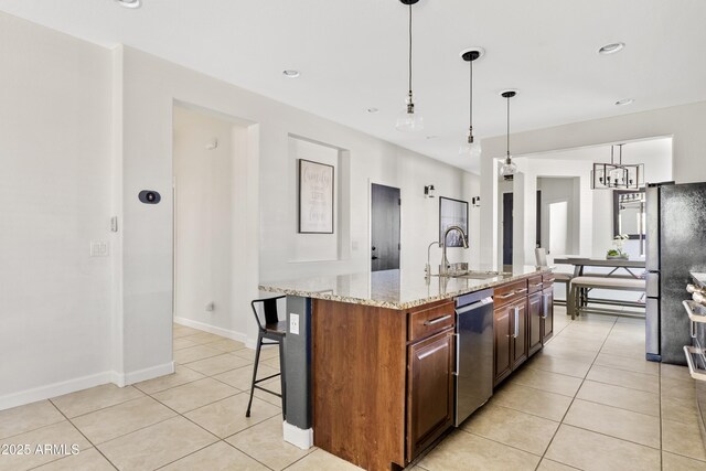 kitchen featuring a sink, light stone countertops, dishwasher, and light tile patterned floors