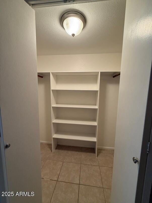 spacious closet with light tile patterned floors