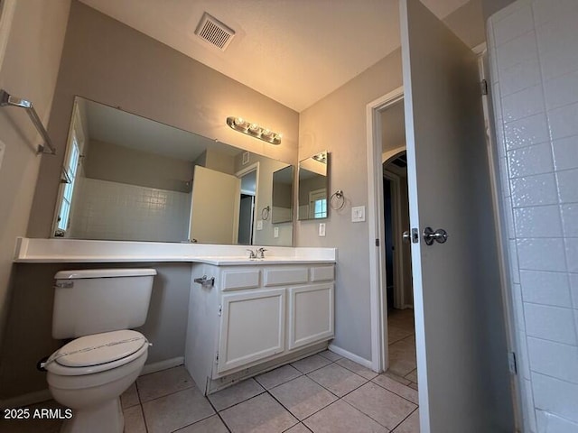 bathroom with tile patterned flooring, vanity, and toilet