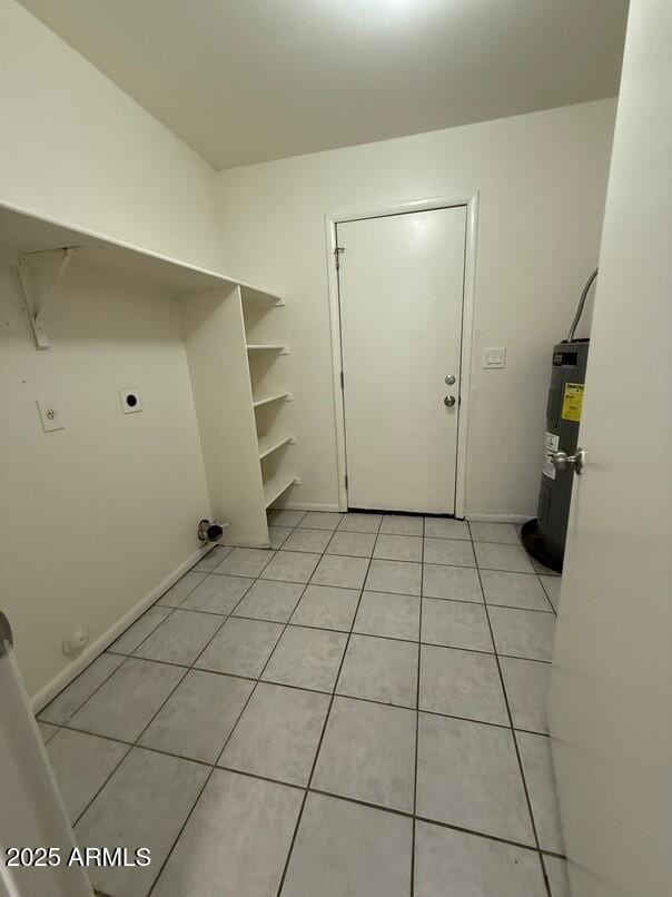 washroom featuring water heater, light tile patterned flooring, and hookup for an electric dryer