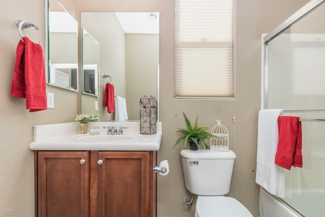 full bathroom with toilet, vanity, and shower / bath combination with glass door