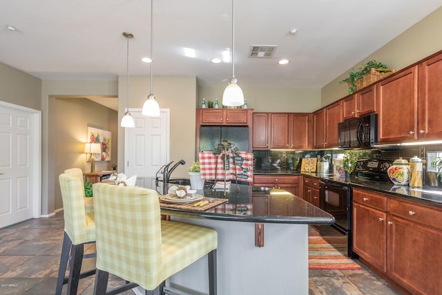 kitchen with backsplash, black appliances, a kitchen breakfast bar, and a kitchen island with sink