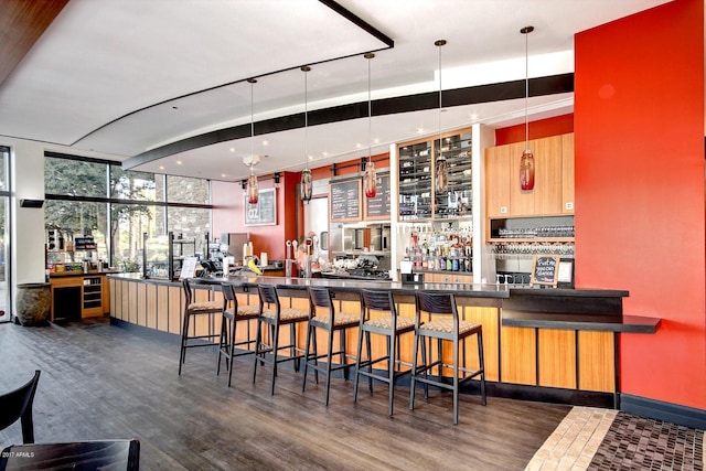 bar featuring expansive windows, dark hardwood / wood-style floors, and decorative light fixtures