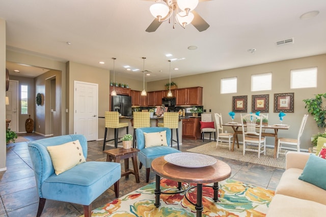 living room with ceiling fan and plenty of natural light