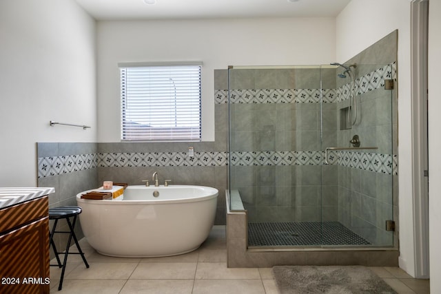 bathroom with separate shower and tub, tile patterned flooring, and tile walls