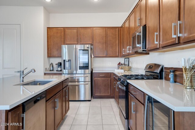 kitchen with light tile patterned floors, stainless steel appliances, beverage cooler, and sink