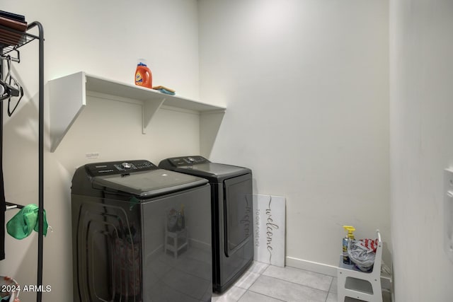 laundry area with washing machine and dryer and light tile patterned floors