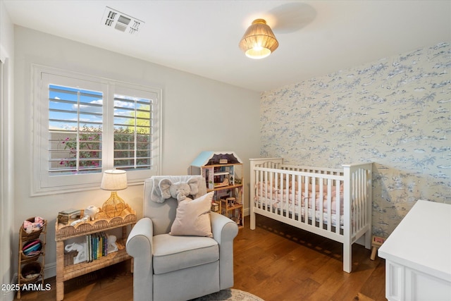 10239 E Salt Bush Dr, Scottsdale, AZ 85255 - bedroom with wallpapered walls, visible vents, a crib, and wood finished floors