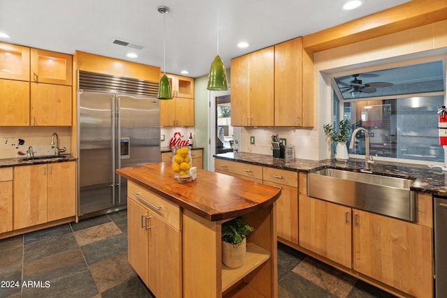 kitchen with butcher block countertops, ceiling fan, sink, and appliances with stainless steel finishes