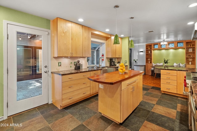 kitchen with light brown cabinets, a center island, butcher block countertops, and pendant lighting