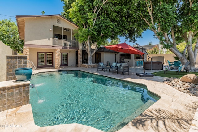 view of swimming pool featuring outdoor lounge area, pool water feature, ceiling fan, a patio, and a hot tub