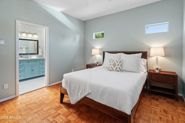 bedroom with ensuite bath, ceiling fan, sink, and light parquet flooring