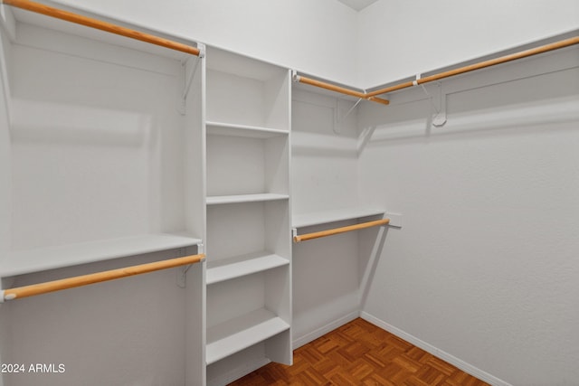 spacious closet featuring parquet floors